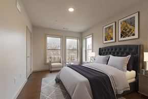 Newton apartment for rent - a bedroom with a bed and a chair and windows