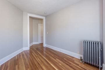 Brighton apartment for rent - the living room of a house with a radiator and wooden floors