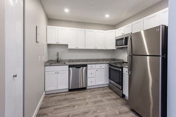 Brighton apartment for rent - an empty kitchen with stainless steel appliances and white cabinets