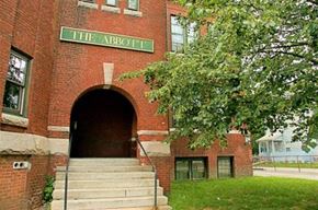 Worcester apartment for rent - a red brick building with a green sign on top of it