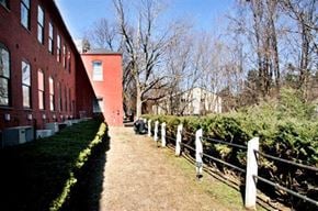 Northborough apartment for rent - an old red brick building with a dirt path and a fence