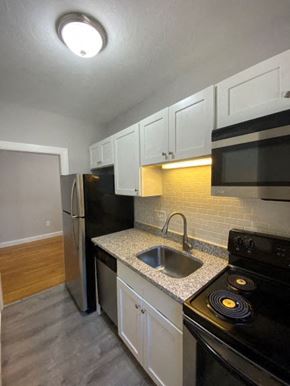Worcester apartment for rent - Kitchen with granite counters, white cabinets and stainless appliances