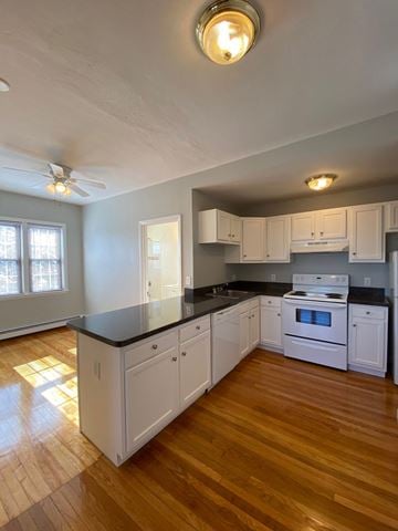 Worcester apartment for rent - a kitchen with white cabinets and a black counter top