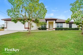 Cape Coral house for rent - a white house with a lawn and a tree