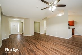 Cape Coral house for rent - an empty living room with wood flooring and a ceiling fan