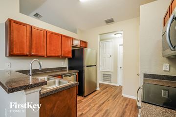 Cape Coral house for rent - a kitchen with granite counter tops and a stainless steel refrigerator
