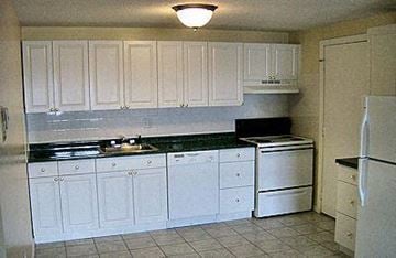 Clinton apartment for rent - a kitchen with white cabinets and a white refrigerator
