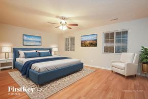 Browns Summit house for rent - A bedroom with a bed, chair, and two pictures on the wall.