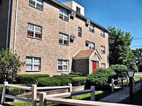 Clinton apartment for rent - an old brick house with a red door and a wooden fence