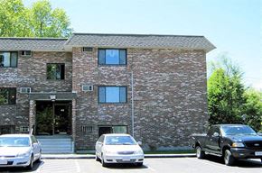Worcester apartment for rent - a brick building with cars parked in a parking lot
