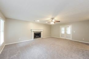 Sugar Hill house for rent - an empty living room with a fireplace and a ceiling fan
