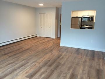 Weymouth apartment for rent - an empty living room with wood flooring and a refrigerator