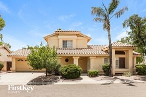 Mesa house for rent - a yellow house with a palm tree in front of it