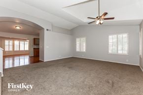 Mesa house for rent - an empty living room with a ceiling fan and a carpet