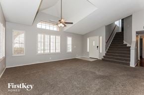 Mesa house for rent - an empty living room with a ceiling fan and a staircase
