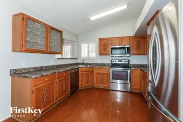 Mesa house for rent - a kitchen with wooden cabinets and stainless steel appliances