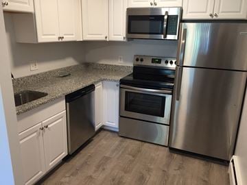 Braintree apartment for rent - a kitchen with stainless steel appliances and white cabinets