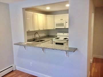 Quincy apartment for rent - a kitchen with white cabinets and a granite counter top