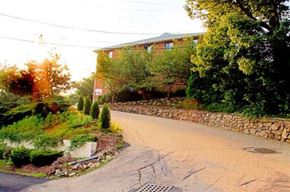 Quincy apartment for rent - a street in front of a house with a stone wall