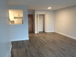 Quincy apartment for rent - an empty living room with wood flooring and white walls