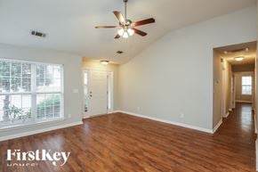 Gainesville house for rent - A room with wooden floors and a ceiling fan.