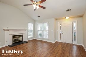 Gainesville house for rent - A room with a fireplace and a ceiling fan.