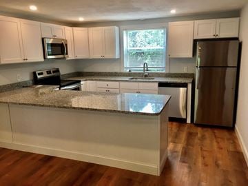 Quincy apartment for rent - a kitchen with white cabinets and a counter top