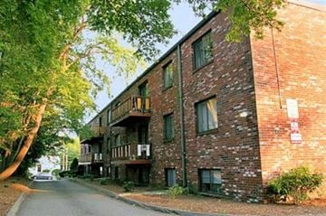 Quincy apartment for rent - a brick apartment building with a street and trees