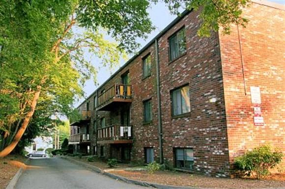 Quincy apartment for rent - a brick apartment building with a street and trees