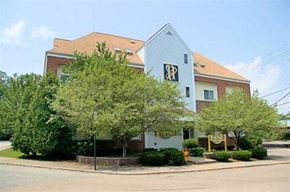 Attleboro apartment for rent - a building with a blue roof and trees in front of it