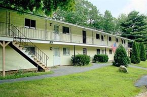 Charlton apartment for rent - a yellow house with a porch and a flag