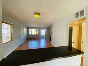 Alexandria house for rent - A spacious living room with a black countertop and a staircase leading to the upper level.