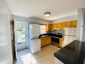 Alexandria house for rent - A kitchen with black countertops and white appliances.