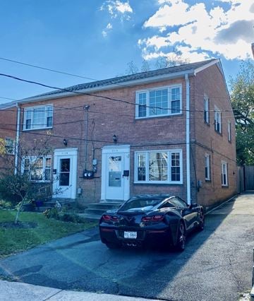Alexandria house for rent - A black sports car is parked in front of a red brick house.