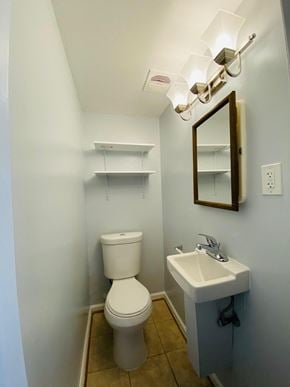 Alexandria house for rent - A small bathroom with a toilet, sink, and mirror.