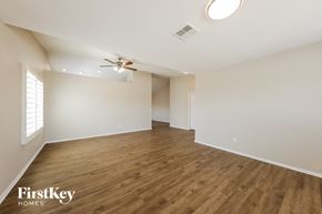 Phoenix house for rent - an empty living room with a ceiling fan and wood flooring