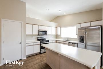 Phoenix house for rent - a large kitchen with white cabinets and stainless steel appliances