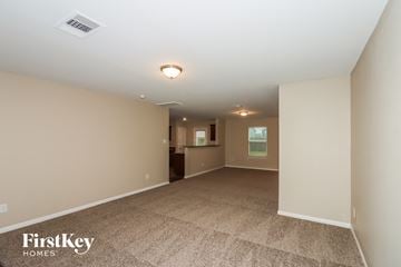Cove house for rent - a spacious living room with carpet and a kitchen