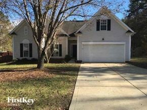 Charlotte house for rent - A house with a white garage door is for sale.