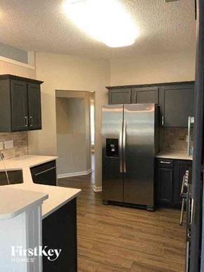 Charlotte house for rent - A kitchen with a stainless steel refrigerator and black cabinets.