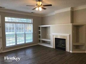 Charlotte house for rent - A living room with a fireplace and a ceiling fan.