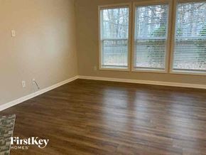 Cumming house for rent - a living room with a hard wood floor and three windows