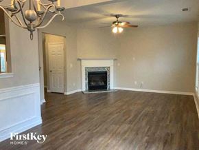 Cumming house for rent - a living room with a fireplace and a ceiling fan