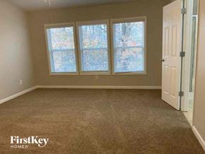 Cumming house for rent - an empty room with three windows and a door