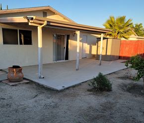 Hemet house for rent - A house with a patio and a wall in the background.