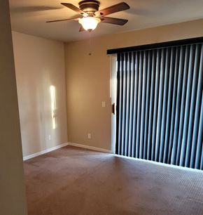 Hemet house for rent - A room with a ceiling fan and a window with blinds.