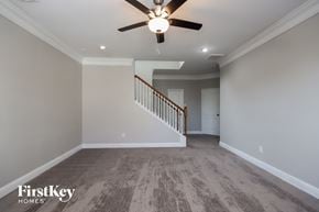 Humble house for rent - an empty living room with a ceiling fan and a staircase