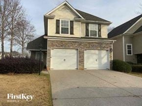 Cumming house for rent - A two-car garage is attached to a house with a stone facade.