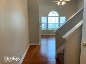 Cumming house for rent - A hallway with a staircase leading to a landing with a window.