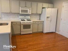 Cumming house for rent - A kitchen with wooden floors and white appliances.